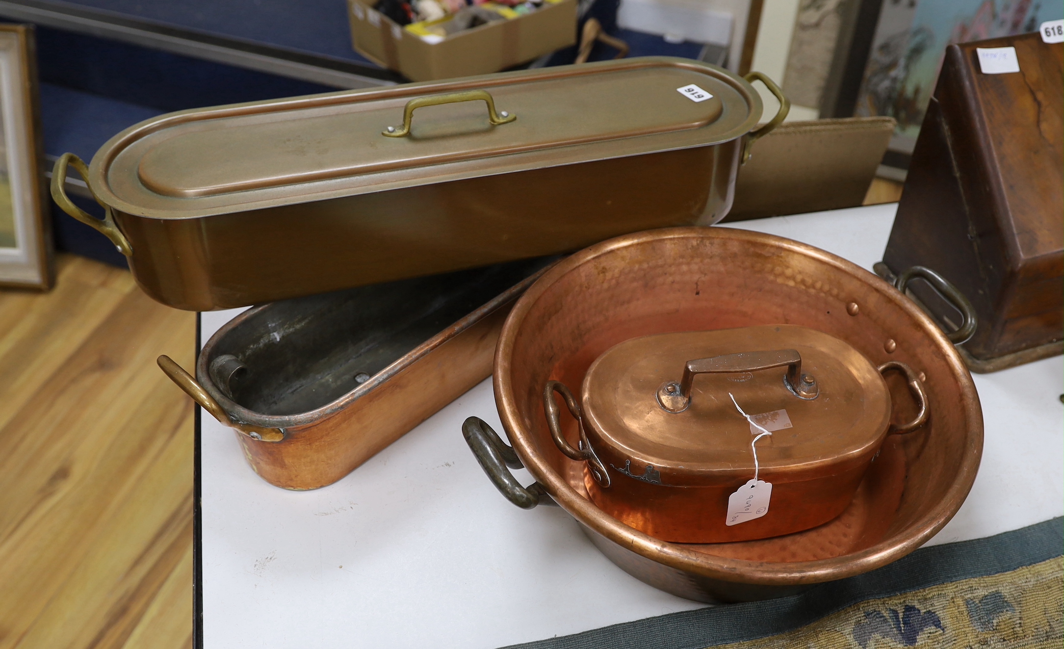 Two copper fish kettles, a casserole dish and cover and a jam making pot, a lidded fish kettle 68cm high